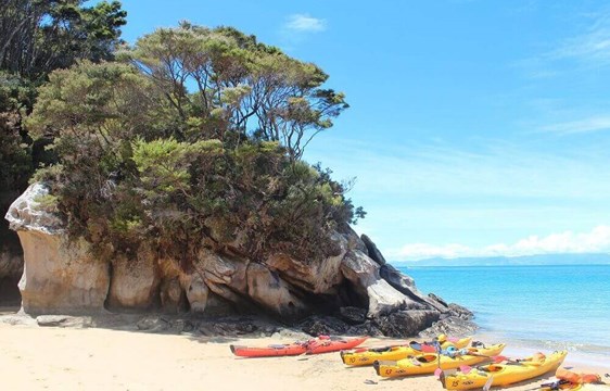 Kayaks on the beach in January in New Zealand's summer