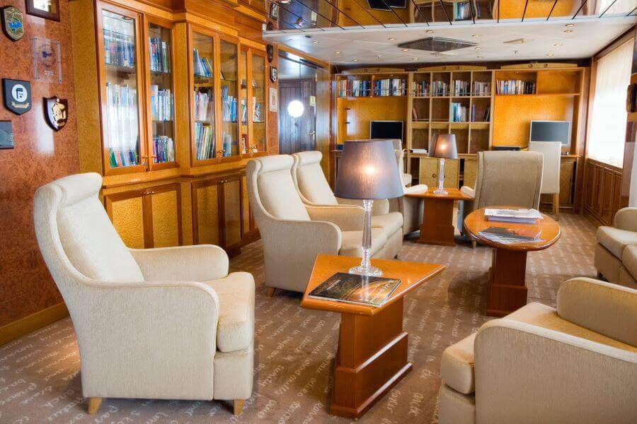 comfy lounge chairs in the library aboard the Island Sky ship