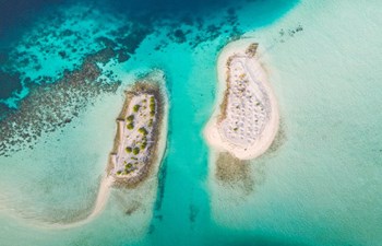 aerial view of white sandy islets surrounded by turquoise water in south ari atoll, maldives