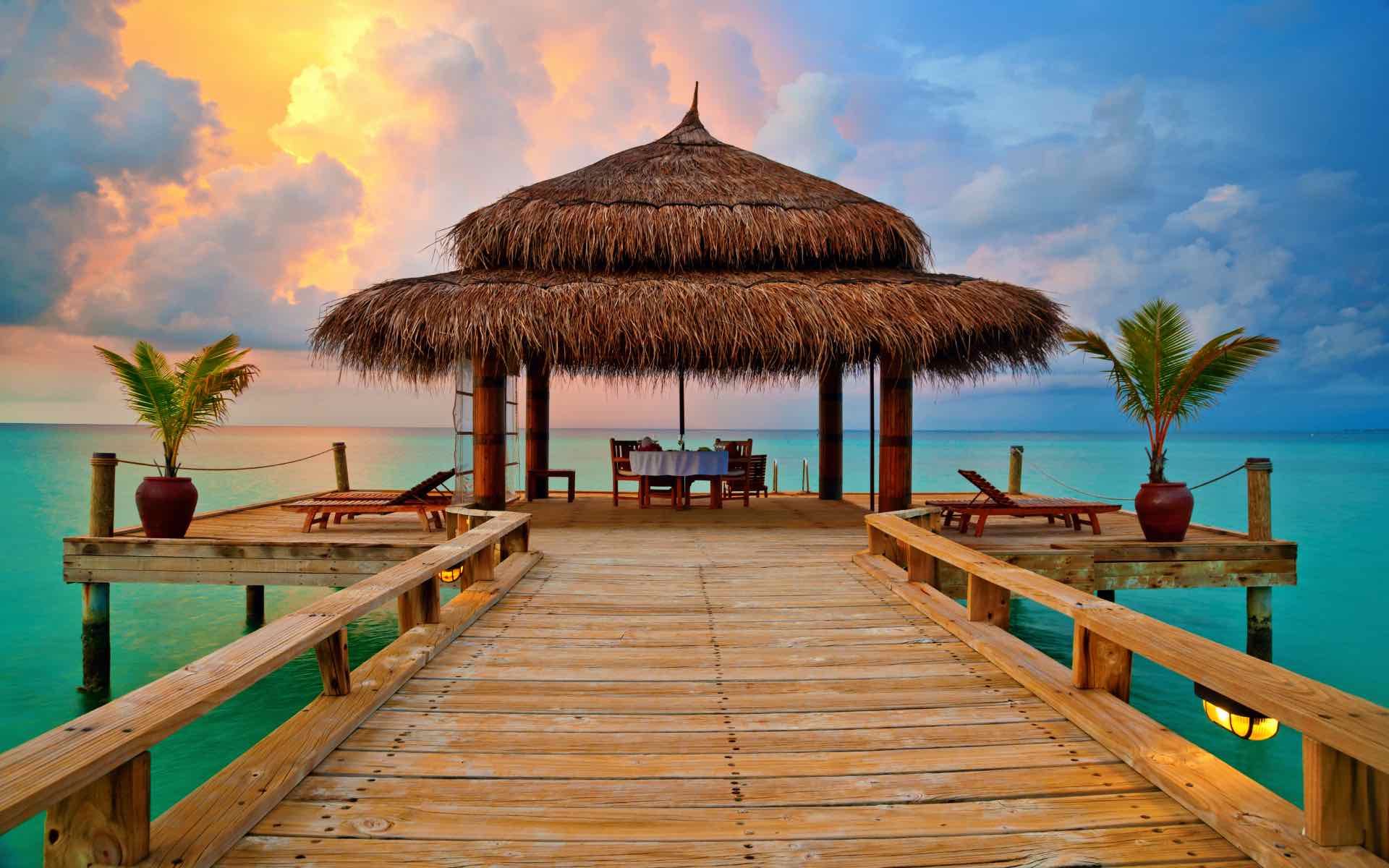Tropical hut on the water at sunset on a Maldives honeymoon in Asia